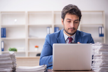 Young male employee and too much work in the office