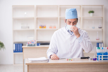 Young male chemist working at the lab