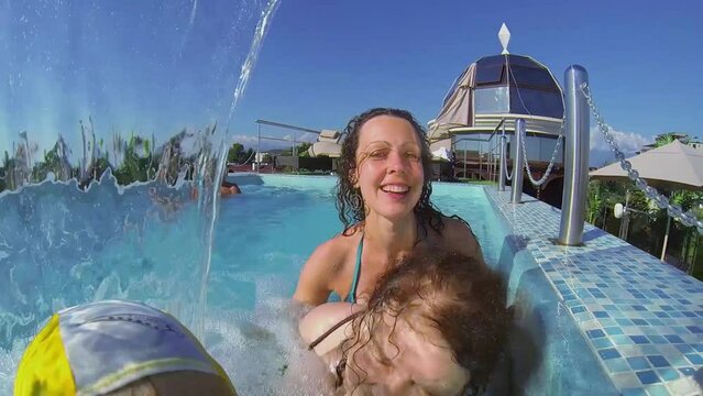 Five members of family get fun under waterfall in pool