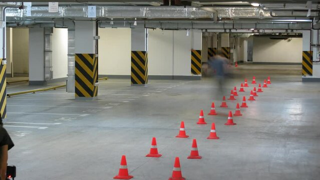 Two men show stunts on roller skates in the underground parking