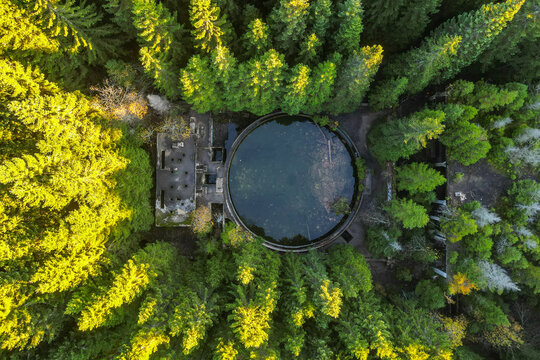 Ruins of former tin mine near Rolava village in the forests of Ore Mountains, Czech Republic. Aerial view from drone.