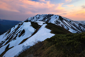 夕焼けの冠雪の北アルプスの稜線