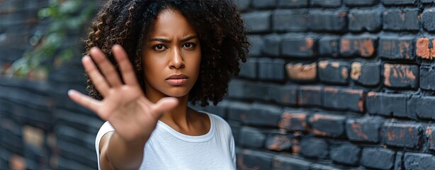 African American woman in a white t shirt shows refusal and disgust with her hands signaling to stop and indicating prohibition - obrazy, fototapety, plakaty