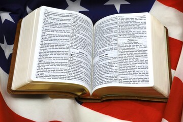 American flag draped under a New Testament bible