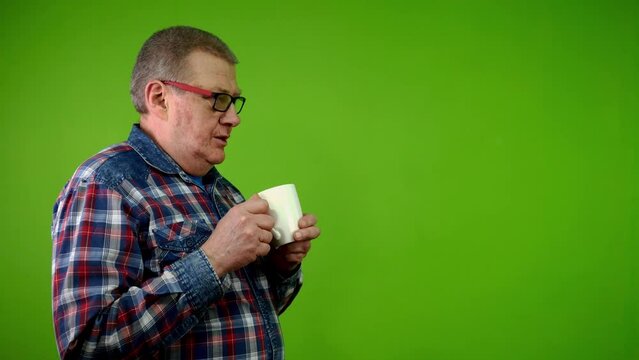 Man with pleasure drinks coffee, tea in white cup.