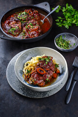 Traditionelles geschmortes italienisches Ossobuco alla Milanese mit Gremolata und Spätzle serviert in einer Nordic Design Schale