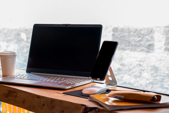 image of a laptop in a scene, with a smartphone holder, a notebook