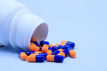 Medicine bottle dumped the pills on a blue background