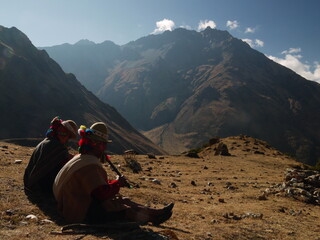 Peruvian hikers in traditional clothes play typical instrument