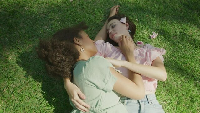 Lesbian couple kissing each other on the grass