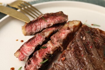 Delicious grilled beef steak with spices on plate, closeup