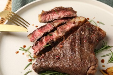 Delicious grilled beef steak and rosemary on plate, closeup
