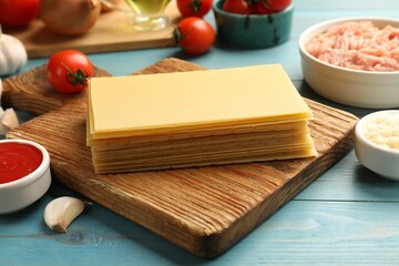 Ingredients for lasagna on blue wooden table, closeup