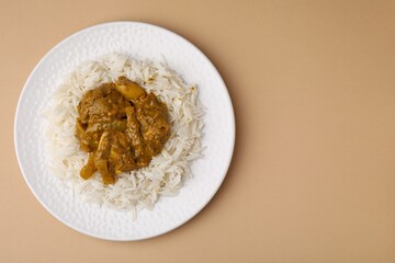 Delicious chicken curry with rice on beige background, top view. Space for text
