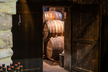 Aging process of cognac spirit in old French oak barrels in cellar in distillery in Cognac white...
