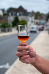 Tasting of cognac alcohol drink and view on old streets and houses in town Cognac, Grand Champagne, Charente, strong spirits distillation industry, France