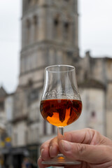 Tasting of cognac alcohol drink and view on old streets and houses in town Cognac, Grand Champagne, Charente, strong spirits distillation industry, France