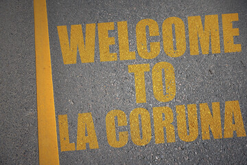 asphalt road with text welcome to La Coruna near yellow line.