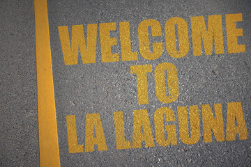 asphalt road with text welcome to La Laguna near yellow line.