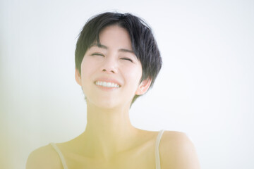 春のかわいい黄色の前ボケのある笑顔の美容イメージ　かわいいアジア系（日本人）女性のクローズアップ カメラ目線