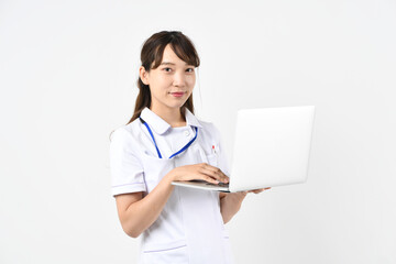 ノートパソコンを見る白衣姿のアジア人女性