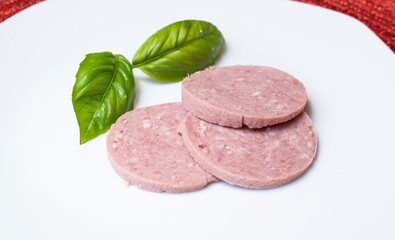 slices of salami with albahaca in white background
