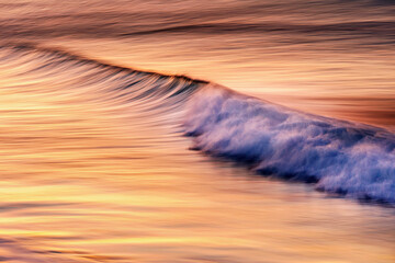 Sunset over Ocean Wave with reflection or orange