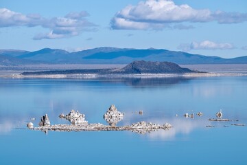 Tufa formations in Mono lake. Calm blue lake with mountains and reflections of clouds. Mono lake....