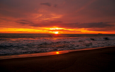 Obraz premium Dramatic seascape sunset with glowing red sky