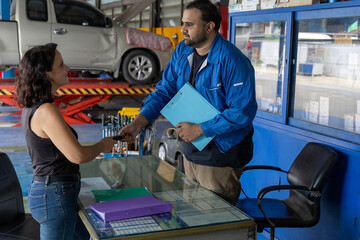 A very attractive women get her car back at the counter of the tire and car service workshop...
