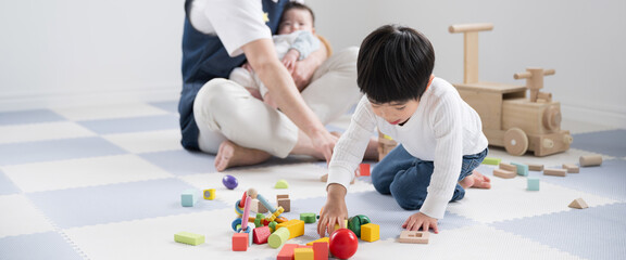 Toddler playing with building blocks at nursery school, home, etc. Banner