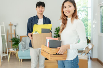 Fototapeta na wymiar Moving house, relocation. Couple help set and move furniture for new apartment, inside the room was a cardboard box contain personal belongings. move in the new apartment or condominium