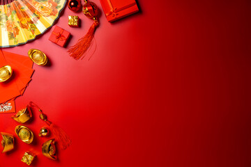Immerse yourself in Chinese New Year ambiance through this top-view arrangement featuring fans, Feng Shui items, symbolic coins, sycee on red setting, ready for text or advertising, card Chinese 