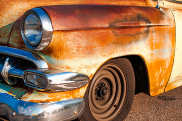 weathered, rusty, patina, left front fender of a vintage automobile, black walled tire with no hub...