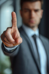 Young businessman wearing suit over office background Pointing with finger up and angry expression, showing no gesture