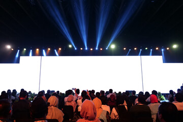 event stage with a crowded audience and a blank screen that can be edited