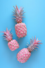 Pink gold painted pineapples on a vivid blue background