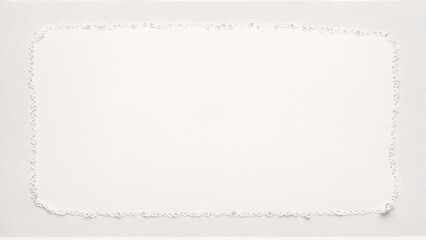 a white square with white thread on top of a piece of paper
