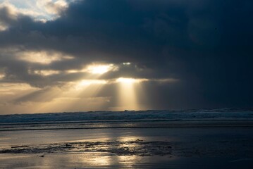 Fototapeta premium Dramatic Seascape with Sun Beams through storm clouds