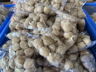 Many packs of chicken and beef meatballs in plastic wrapping for sale in local market