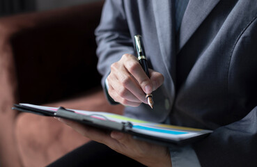 businesswoman sit at their desks and calculate financial graphs showing results about their...