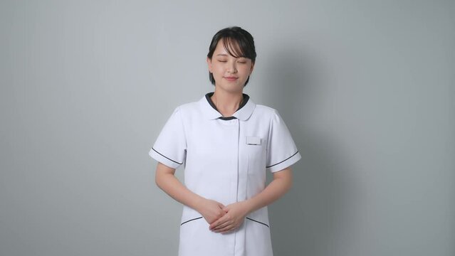 お辞儀する白衣を着た女性
