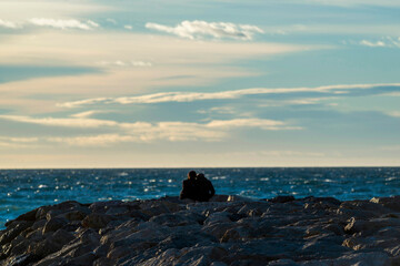 Couple au bord de la mer au coucher du soleil