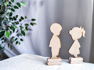 Wooden toys boy and girl on a fabric background. A couple in love on Valentine's Day. A celebration...