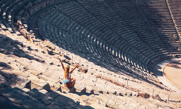 Female tourist enjoying the ancient theatre of Epidaurus, Peloponnese in Greece
