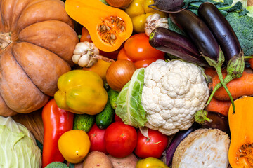 Various vegetables are laid out on a wooden table. Large assortment of vegetables food. pumpkin...