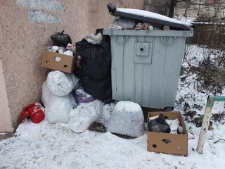 Trash in bags near the bin.