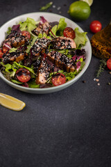 tuna steak salad with sesame seeds and teriyaki sauce in a ceramic bowl