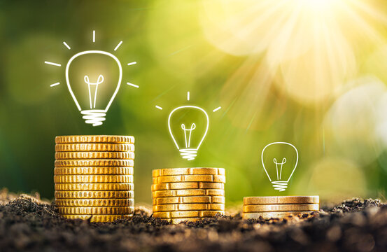 The coins are stacked on the ground and there is a light bulb on top, the idea of saving money. idea saving energy and accounting finance concept. Ideas to make more money. financial business ideas.