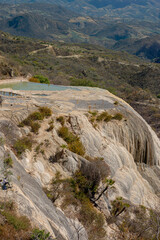 Girl on top of a white mountain with blue lakes and springs in Mexico hierve del agua